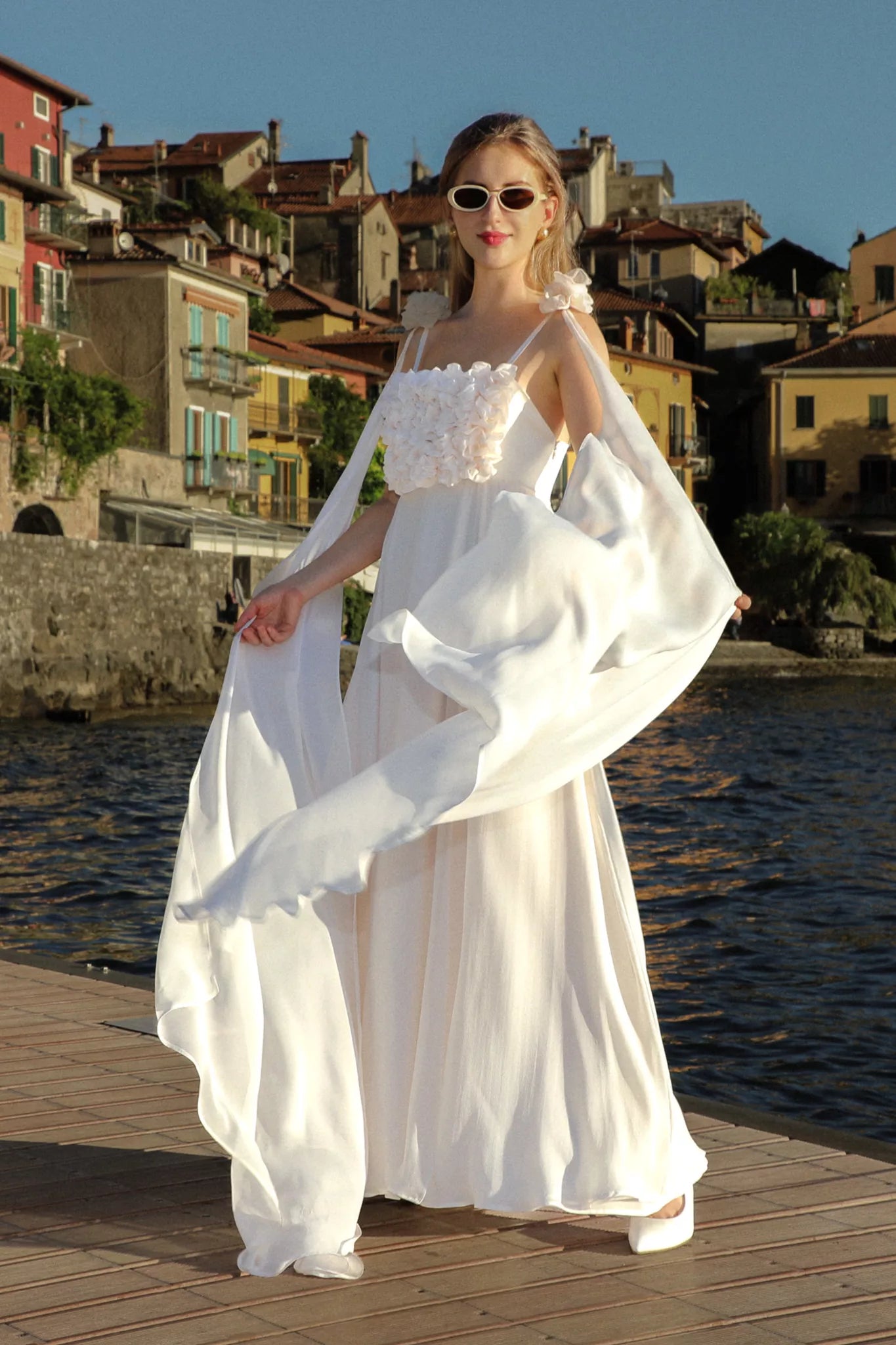 Aria silk chiffon wedding dress by FRAQAIR, cape catching the wind on a Lake Como promenade