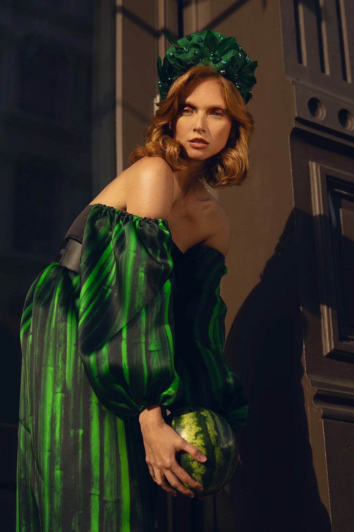 FRAQAIR green stripe sleeves and jewelled headpiece, the model leaning forward with a watermelon