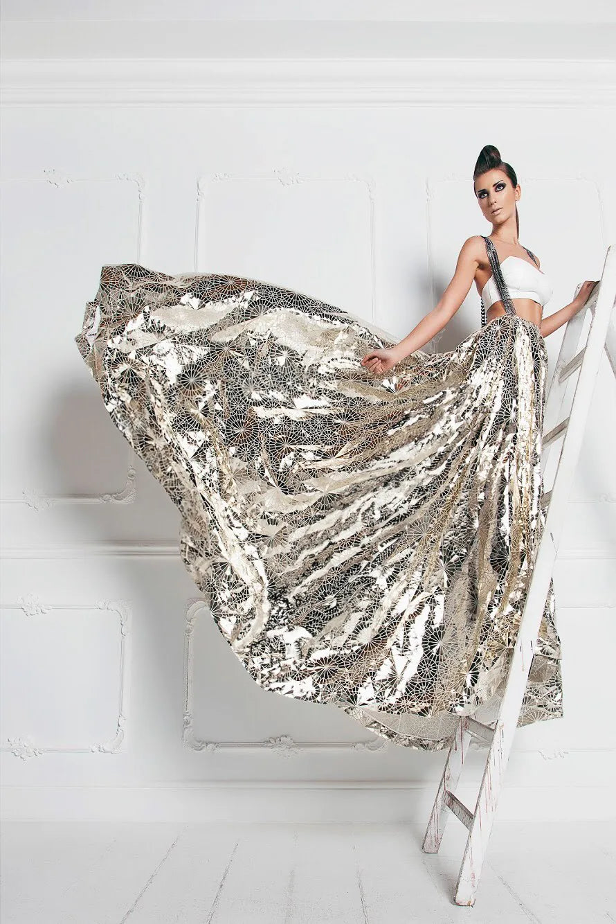 FRAQAIR metallic ball skirt flying out from a white ladder, with a white bustier on chain straps